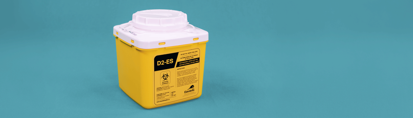 Yellow sharps disposal container with a white lid on a blue background