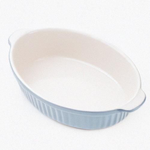 Empty blue ceramic oval baking dish on a white background