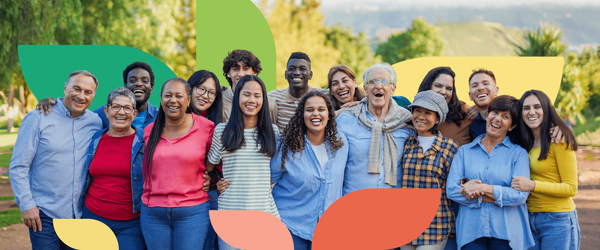 A happy group of 16 diverse people smiling with their arms around one another
