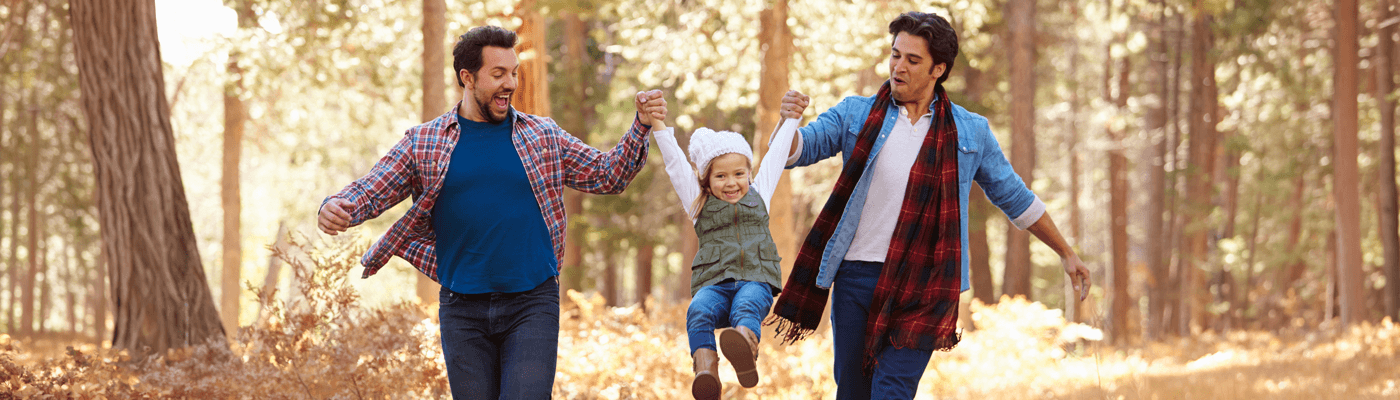Parents swinging their daughter in the air by her arms